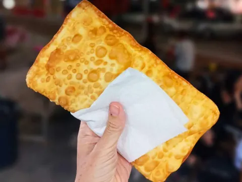 Pastel brasileiro dourado com massa crocante e bolhas